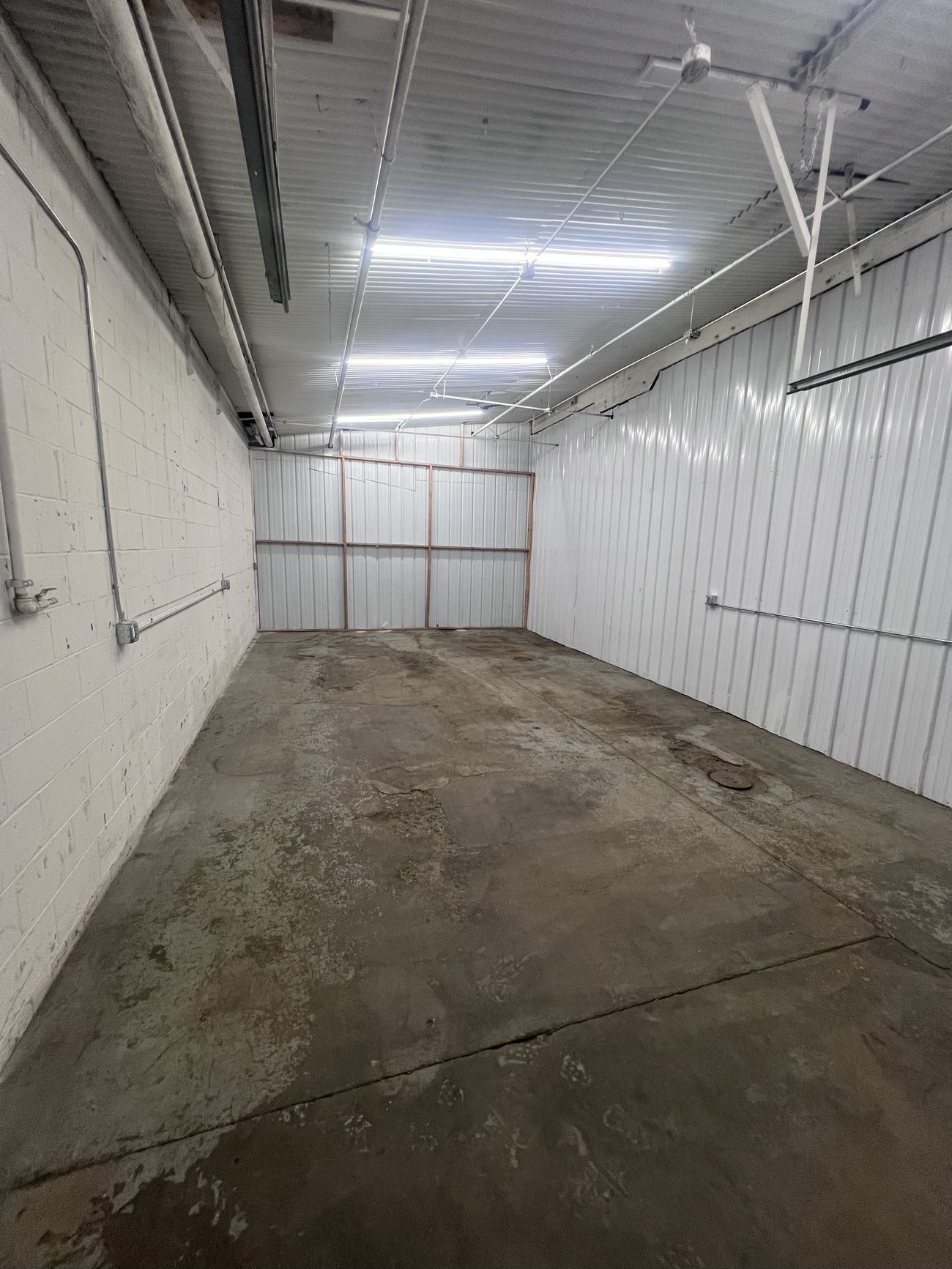 Zone R after renovation: the same narrow bay, lined in white panel and lit end to end.